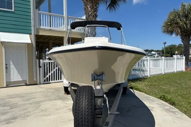 Slide: The Image of 2013 Key West 189 FS boat on trailer, parked near a house with palm trees. - 3