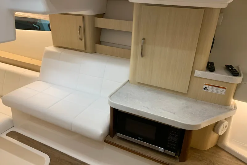 Slide: The Image of Interior of 2024 Regal 36 Grande Coupe with white seating and wooden cabinetry. - 22
