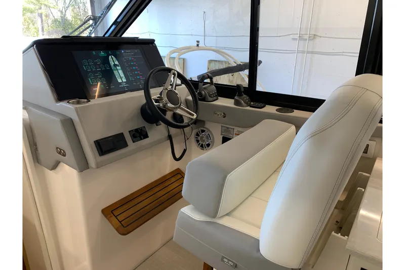 Slide: The Image of Helm of 2024 Regal 36 Grande Coupe with modern controls and plush seating. - 3