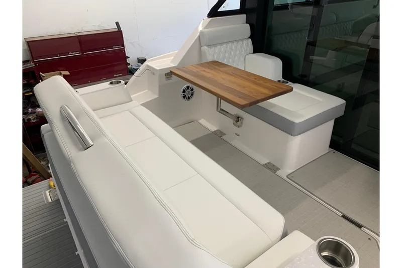 Slide: The Image of 2024 Regal 36 Grande Coupe interior with white seating and wooden table. - 32