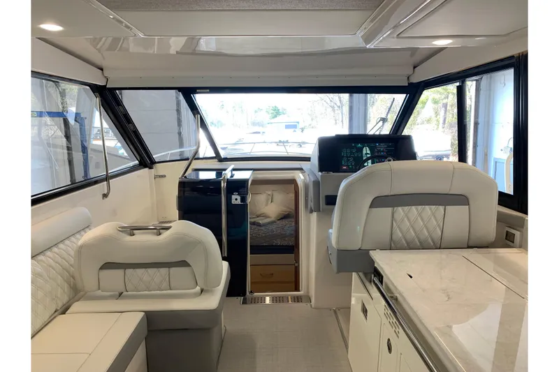Slide: The Image of Interior of 2024 Regal 36 Grande Coupe, featuring luxurious seating and modern helm controls. - 34