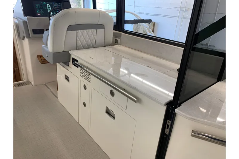 Slide: The Image of 2024 Regal 36 Grande Coupe interior with sleek white cabinetry and modern helm station. - 35