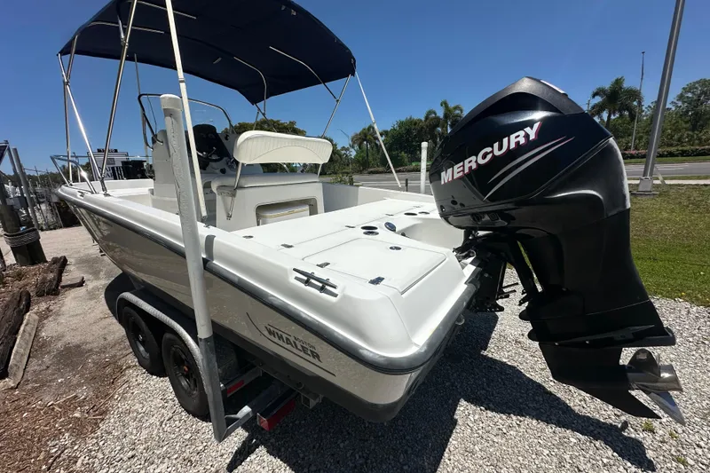 Slide: The Image of 2007 Boston Whaler 200 Dauntless boat with Mercury outboard motor, parked on a trailer. - 6