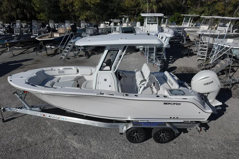 Slide: The Image of 2026 Sea Fox 228 Commander boat on trailer, displayed at a marina. - 2