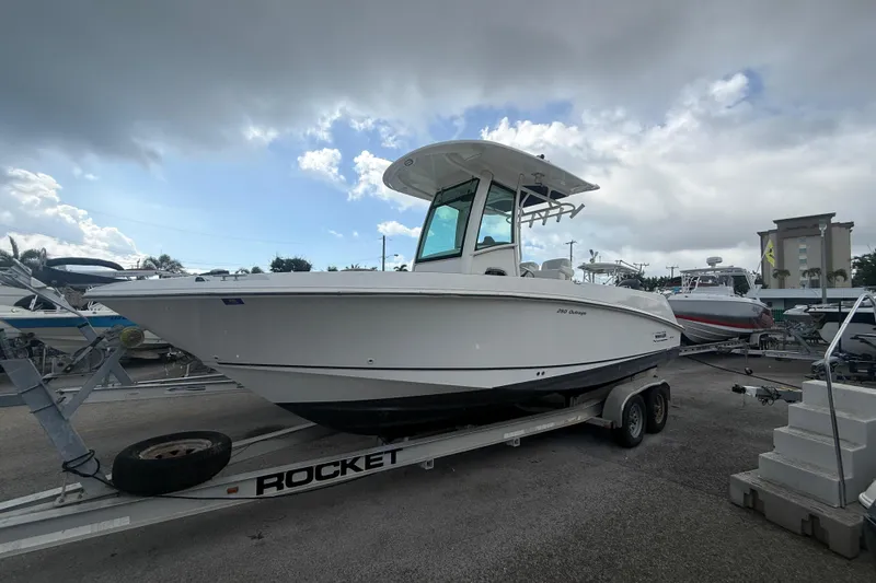 The Image of 2014 Boston Whaler 250 Outrage boat on trailer under cloudy sky. - 1