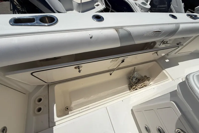 Slide: The Image of 2014 Boston Whaler 250 Outrage boat storage compartment with rope, showcasing interior features. - 12