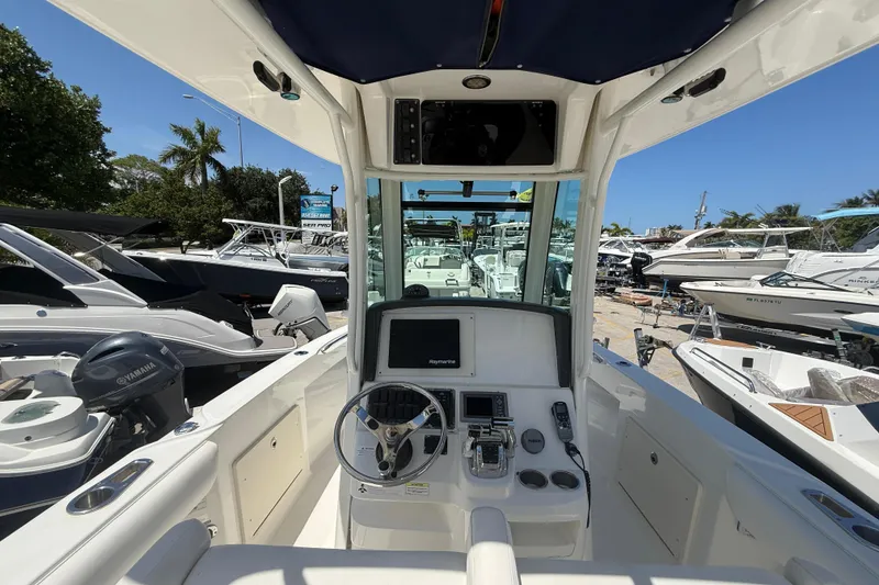 Slide: The Image of 2014 Boston Whaler 250 Outrage boat interior with steering wheel and control panel. - 13
