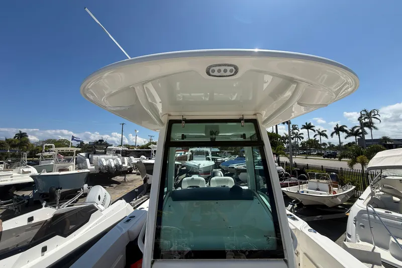 Slide: The Image of 2014 Boston Whaler 250 Outrage boat with T-top, parked in a sunny marina. - 23