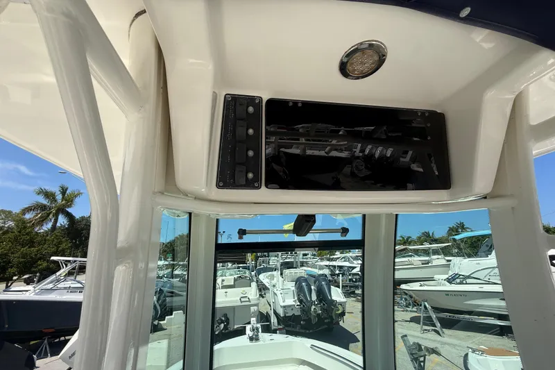 Slide: The Image of 2014 Boston Whaler 250 Outrage helm with electronic controls and overhead storage. - 27
