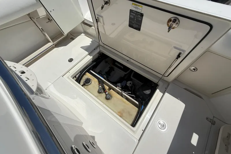 Slide: The Image of 2014 Boston Whaler 250 Outrage open hatch showing internal components and storage. - 5
