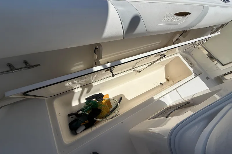 Slide: The Image of 2014 Boston Whaler 250 Outrage storage compartment with fishing gear inside. - 9