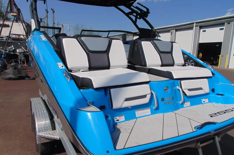 Slide: The Image of 2022 Yamaha Boats 255XD with blue exterior and comfortable seating, parked outdoors. - 4