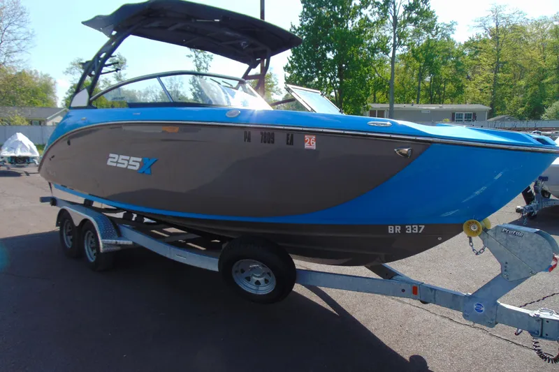Slide: The Image of 2022 Yamaha Boats 255XD on trailer, blue and gray design, parked outdoors. - 7