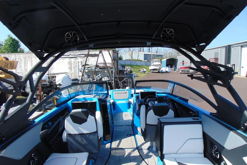Slide: The Image of 2022 Yamaha Boats 255XD interior with blue and white seating, modern dashboard, and open canopy. - 9
