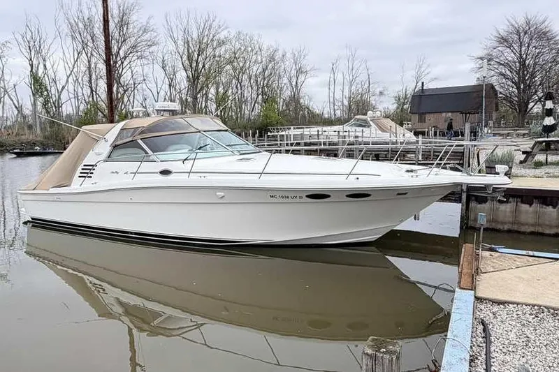 The Image of 1998 Sea Ray 370 Express Cruiser docked in a serene marina setting. - 1