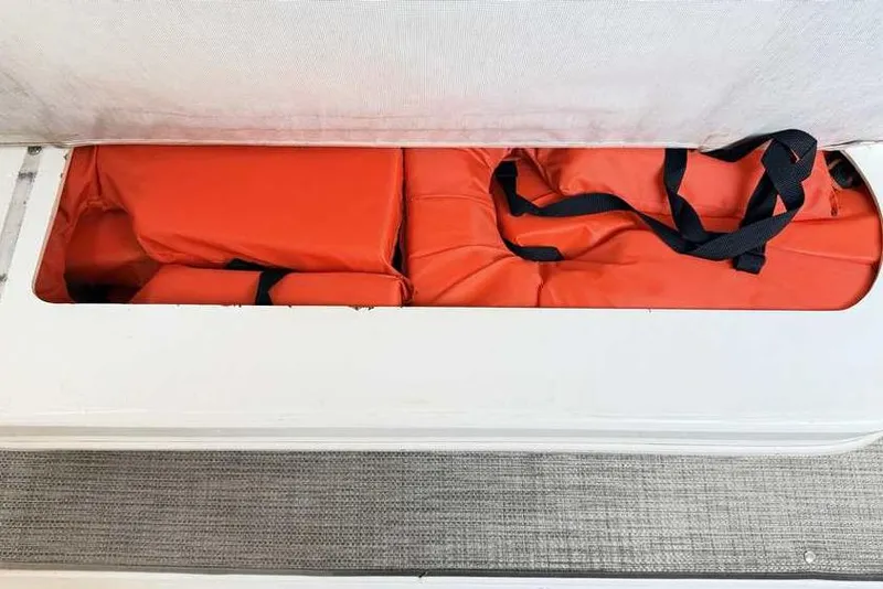 Slide: The Image of Storage compartment with orange life jackets on a 1998 Sea Ray 370 Express Cruiser. - 14
