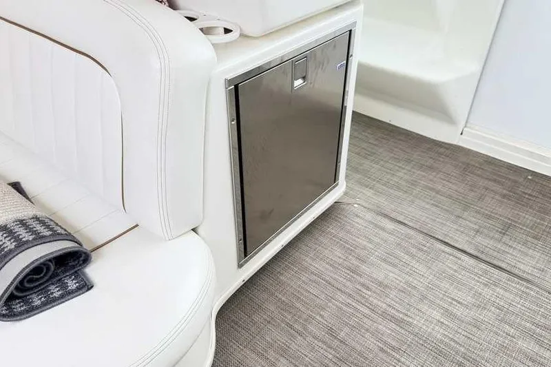 Slide: The Image of Interior of 1998 Sea Ray 370 Express Cruiser with white seating and compact fridge. - 15