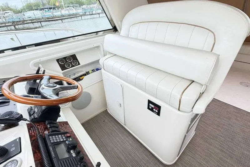 Slide: The Image of Interior of 1998 Sea Ray 370 Express Cruiser with helm and white seating. - 19