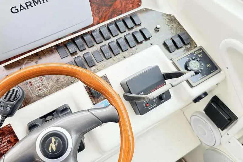 Slide: The Image of 1998 Sea Ray 370 Express Cruiser helm with Garmin navigation and wood-trimmed steering wheel. - 25