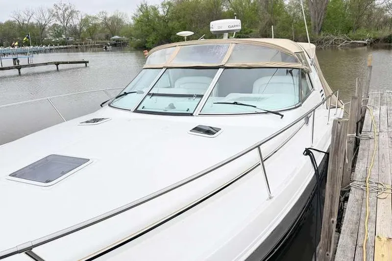Slide: The Image of 1998 Sea Ray 370 Express Cruiser docked by a serene riverside. - 3