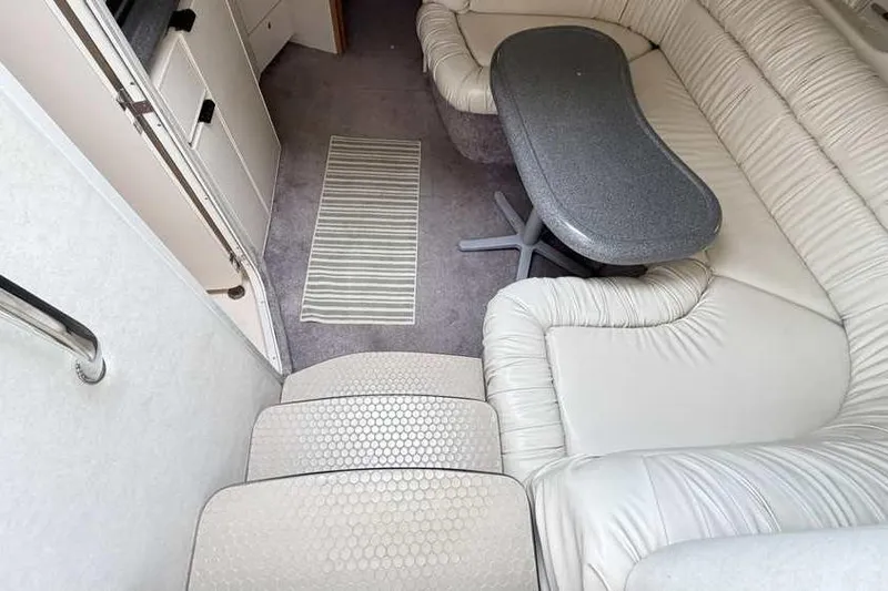 Slide: The Image of Interior of 1998 Sea Ray 370 Express Cruiser with plush seating and table. - 31