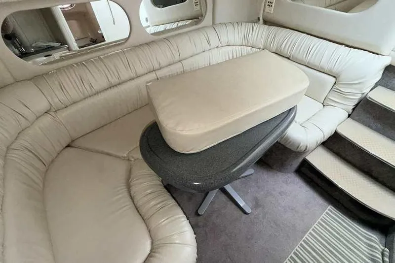 Slide: The Image of Interior of 1998 Sea Ray 370 Express Cruiser with beige leather seating and table. - 32