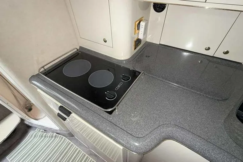 Slide: The Image of 1998 Sea Ray 370 Express Cruiser kitchen with electric stove and sleek countertops. - 36