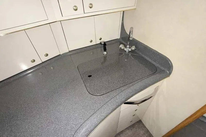 Slide: The Image of Compact kitchen area in a 1998 Sea Ray 370 Express Cruiser yacht. - 37