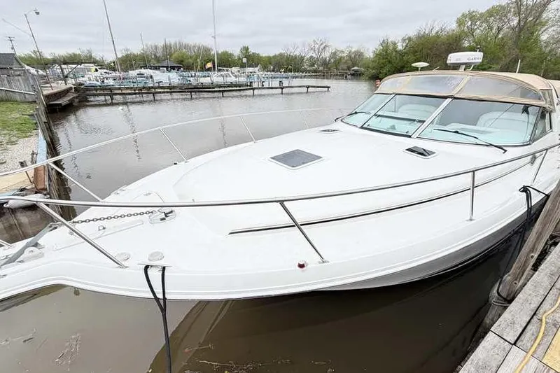 Slide: The Image of 1998 Sea Ray 370 Express Cruiser docked at a marina, showcasing sleek design. - 4