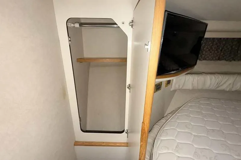 Slide: The Image of Interior of 1998 Sea Ray 370 Express Cruiser with open closet and bed. - 43