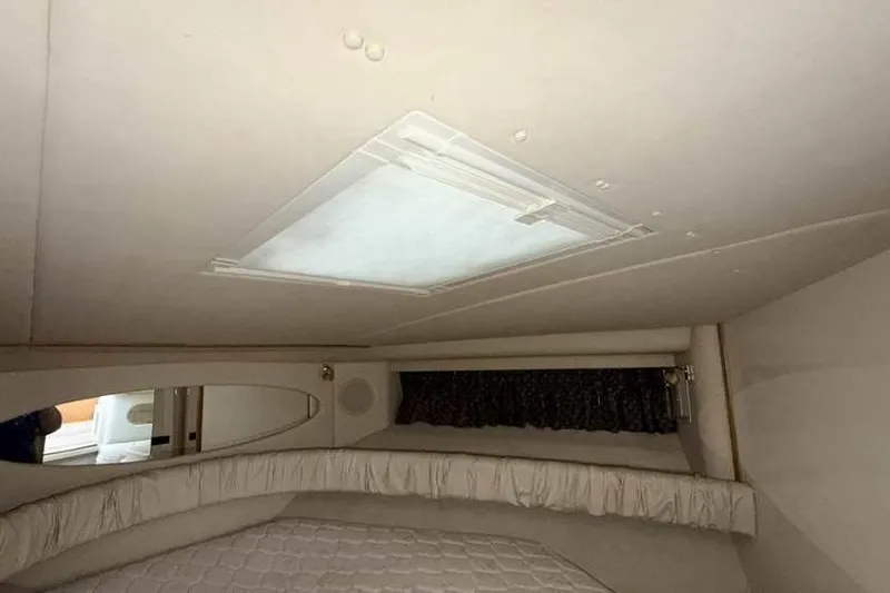 Slide: The Image of Interior cabin of 1998 Sea Ray 370 Express Cruiser with bed and ceiling hatch. - 46