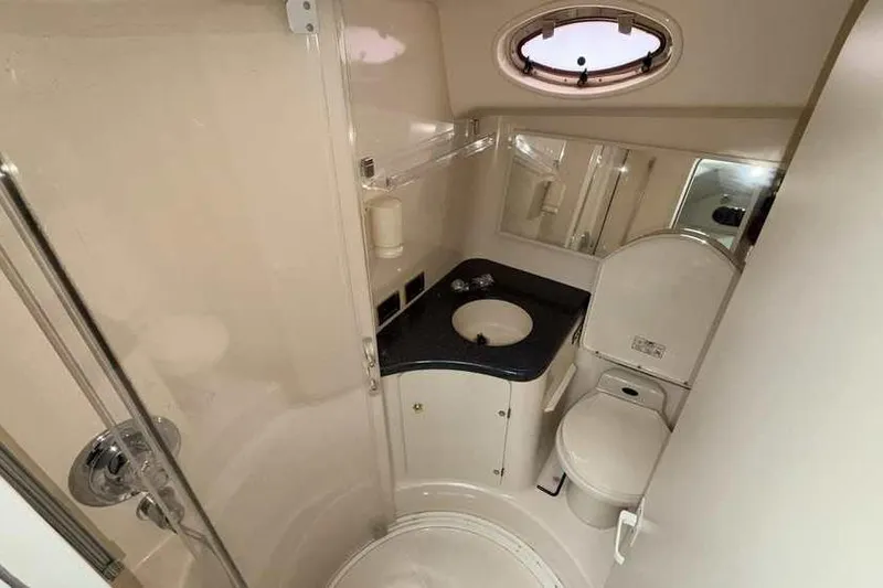 Slide: The Image of 1998 Sea Ray 370 Express Cruiser bathroom with sink, toilet, and shower. - 48