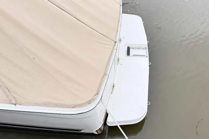 Slide: The Image of 1998 Sea Ray 370 Express Cruiser with beige cover on water. - 7