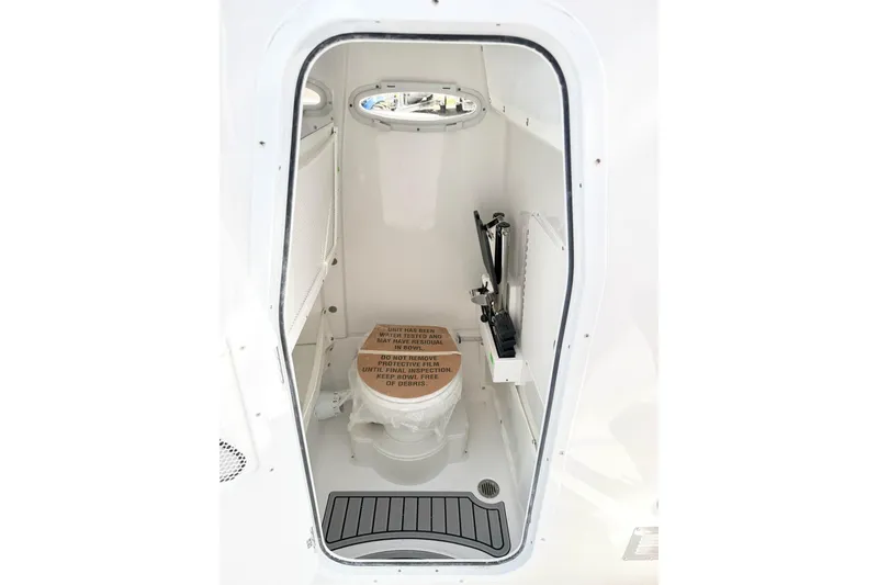 Slide: The Image of Interior of 2026 Sea Hunt Ultra 255 SE boat, featuring a compact marine toilet. - 25