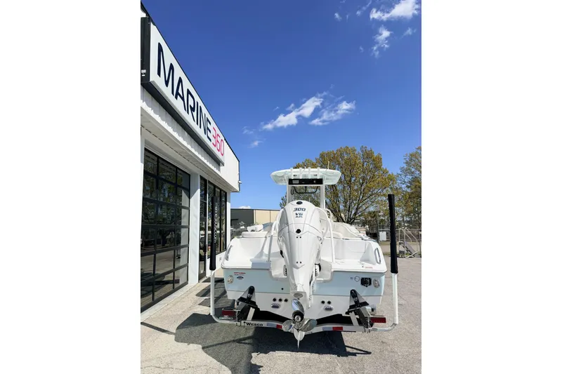 Slide: The Image of 2026 Sea Hunt Ultra 255 SE boat at Marine 360 dealership under clear blue sky. - 3