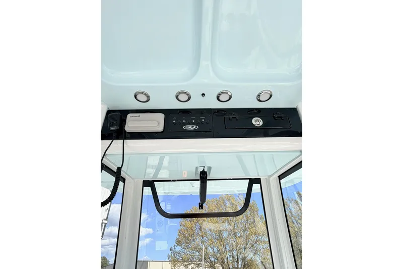 Slide: The Image of 2026 Sea Hunt Ultra 255 SE boat console with Garmin electronics and overhead controls. - 9
