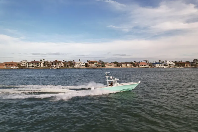 Slide: The Image of SeaVee 390B 2013 boat cruising on open water near coastal homes. - 9