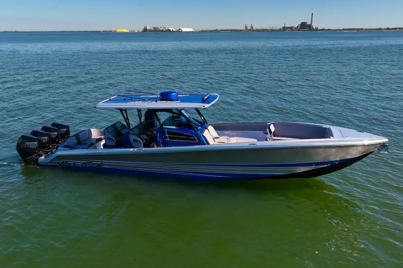 The Image of 2025 Nor-Tech 390 Sport Center Console boat on calm water, featuring multiple outboard engines. - 0
