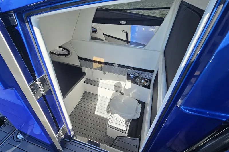 Slide: The Image of Interior of 2025 Nor-Tech 390 Sport Center Console boat, featuring compact bathroom amenities. - 32