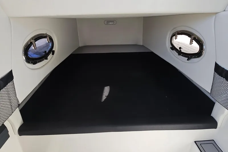 Slide: The Image of 2025 Nor-Tech 390 Sport Center Console cabin interior with portholes and black seating. - 33