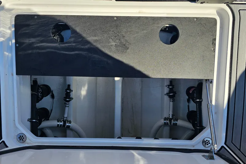 Slide: The Image of 2025 Nor-Tech 390 Sport Center Console boat interior compartment with visible plumbing components. - 43