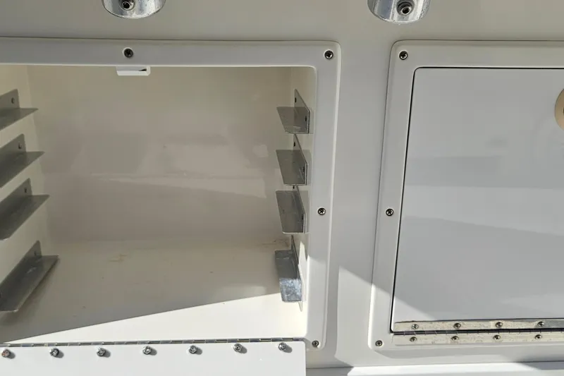 Slide: The Image of 2007 SeaCraft SC32 Master Angler storage compartments with metal brackets and secure latches. - 13