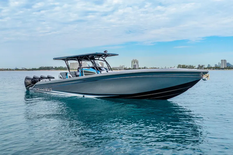 The Image of 2024 Nor-Tech 390 Sport Center Console boat on calm water, city skyline in background. - 1