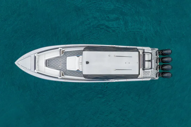 Slide: The Image of 2024 Nor-Tech 390 Sport Center Console boat on clear blue water, aerial view. - 10