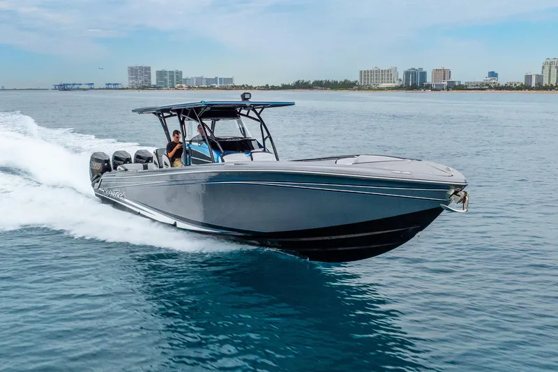 Slide: The Image of 2024 Nor-Tech 390 Sport Center Console cruising on open water, city skyline in background. - 11