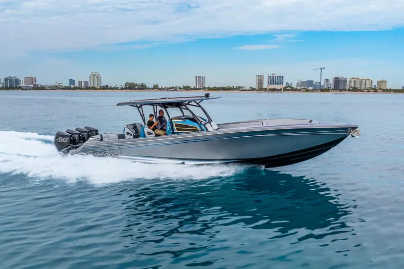 Slide: The Image of 2024 Nor-Tech 390 Sport Center Console cruising on water with city skyline in background. - 12