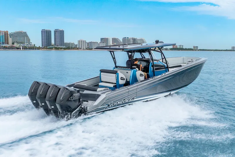 Slide: The Image of 2024 Nor-Tech 390 Sport Center Console cruising on water with city skyline backdrop. - 14