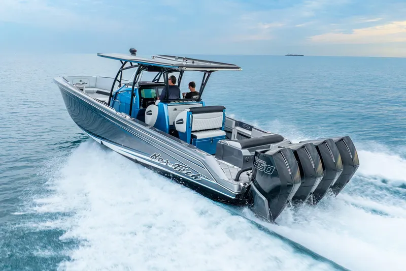 Slide: The Image of 2024 Nor-Tech 390 Sport Center Console boat cruising on open water with four powerful engines. - 18