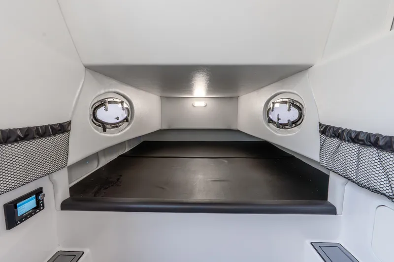 Slide: The Image of 2024 Nor-Tech 390 Sport Center Console cabin interior with portholes and modern amenities. - 26
