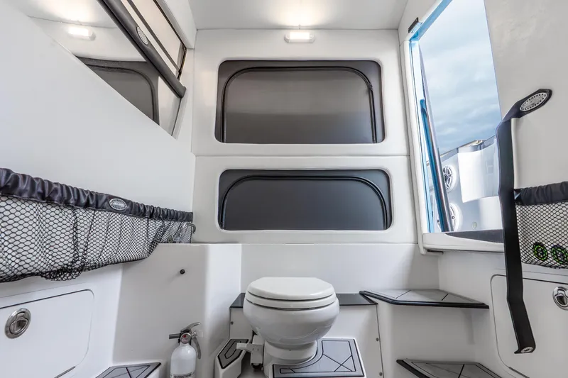 Slide: The Image of Interior of 2024 Nor-Tech 390 Sport Center Console boat, featuring modern bathroom amenities. - 27